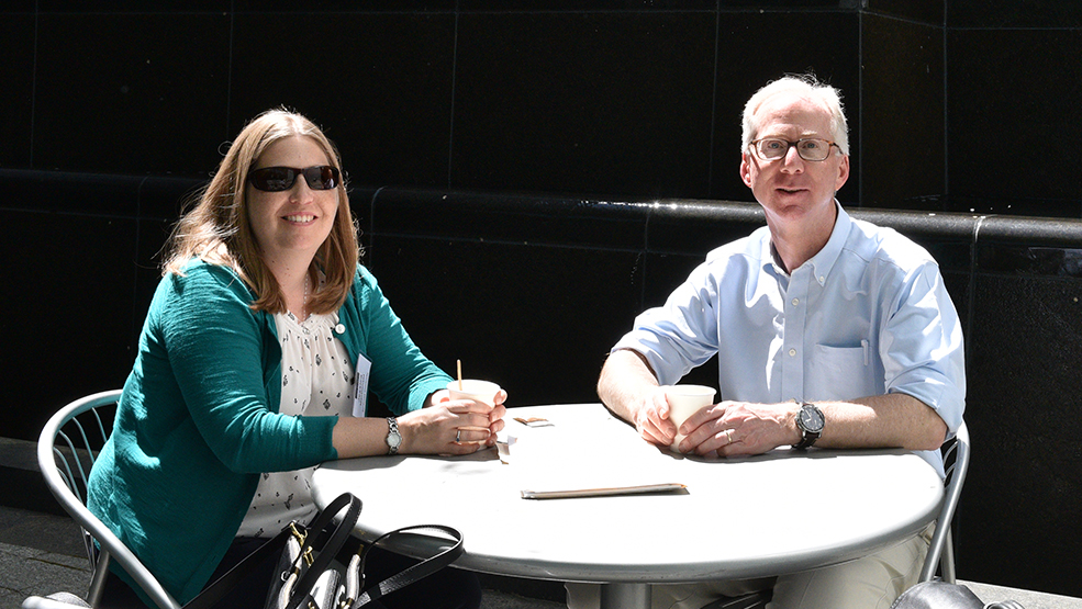Jessica MacDonald and Jeff Macklis sit in the sun in front of a fountain