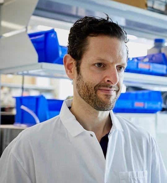 Man wearing white lab coat in a lab