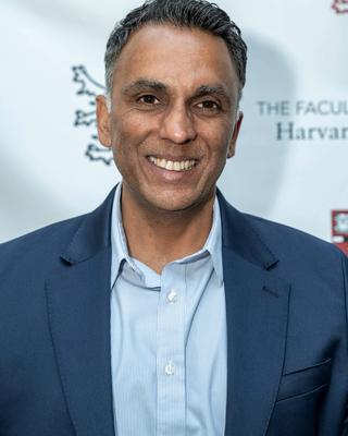 Professor Amar Sahay in blue blazer and buttondown shirt