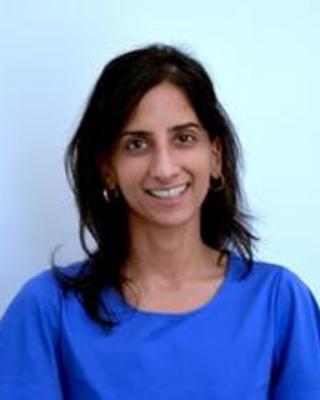 Woman with shoulder length dark hair wearing a bright blue shirt