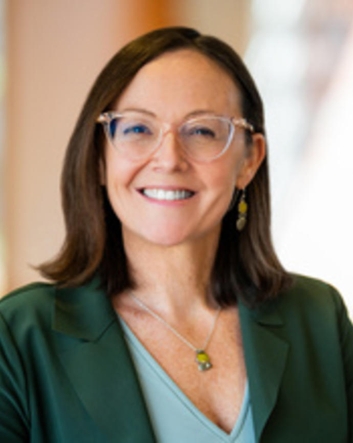 Person wearing a green blazer and glasses